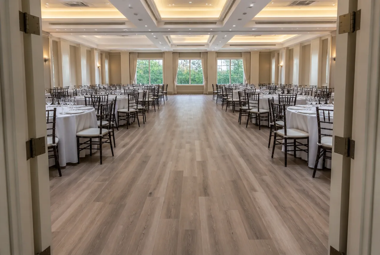 A clear continuous path running between set banquet tables from a doorway to the far side of a hall with even light.