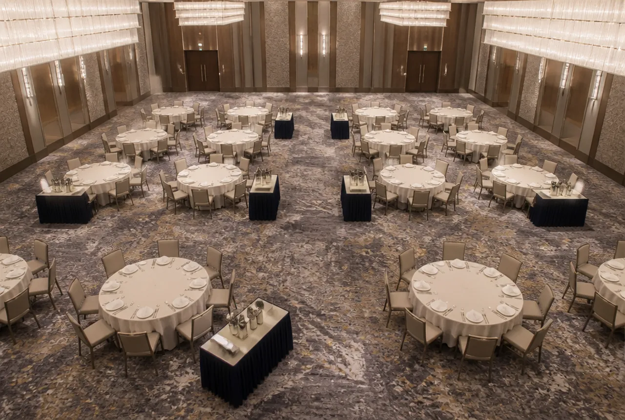 A set hall with small skirted service stations placed at the edges of separate table blocks.