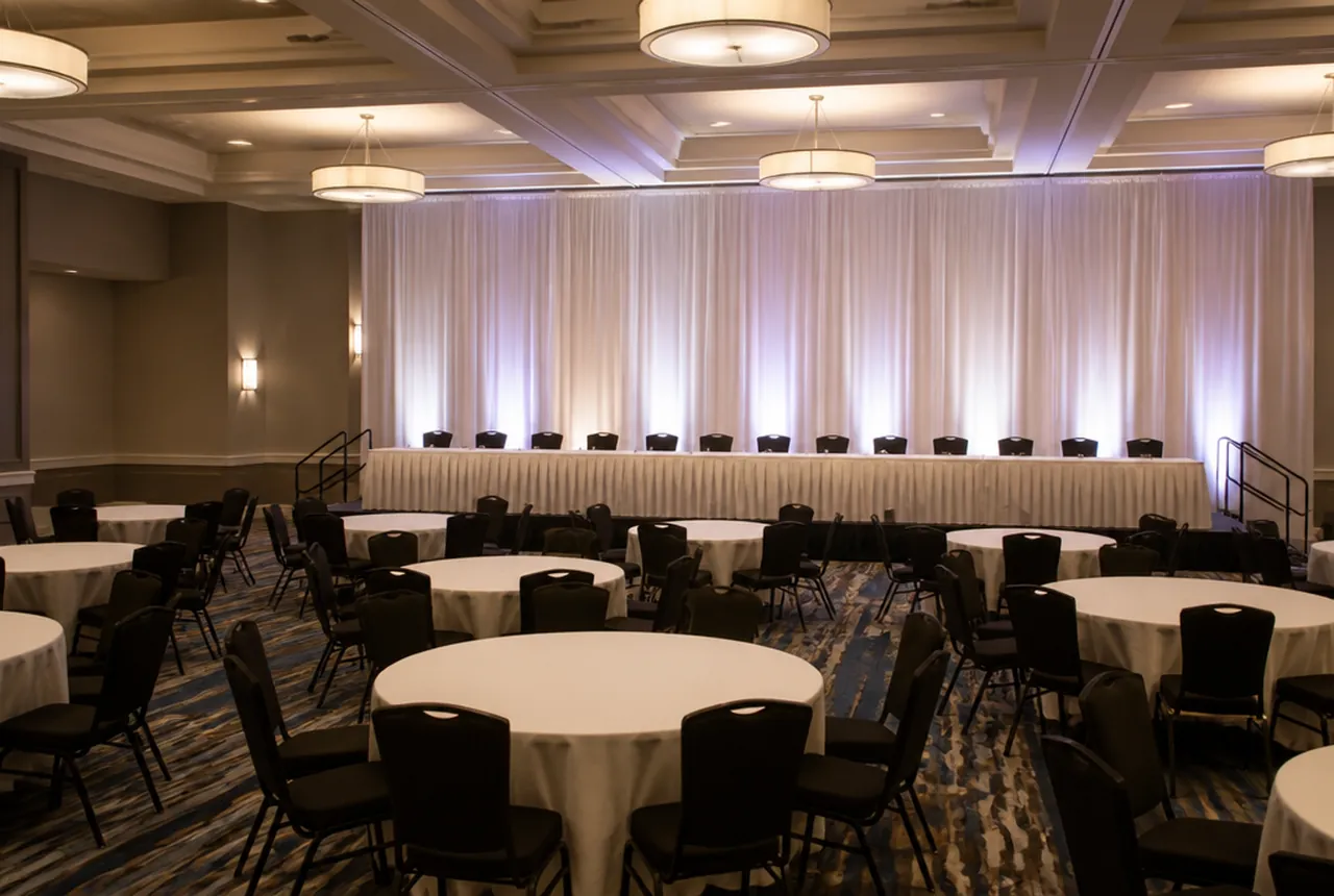 Head table raised on a riser at the front of the room, seated on one side only and facing the guest tables